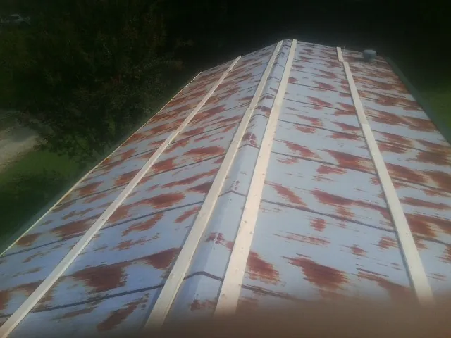 Rusted metal roof panels with new wood purlins before replacement — Storm Damage Roof Repair in Calimesa by Roofing Brothers