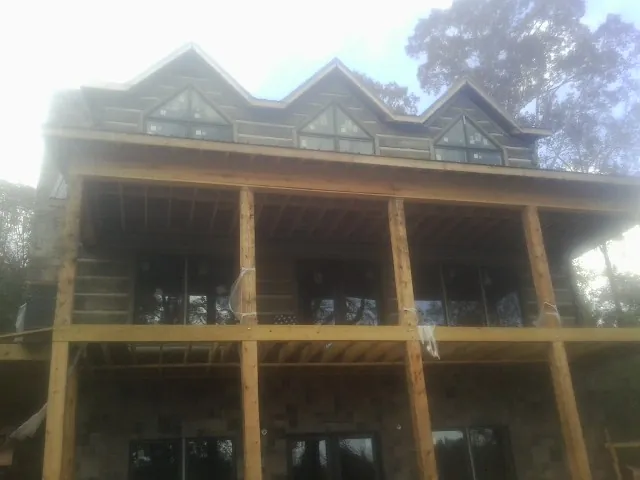Dormers and porch framing on a large log home under construction — Roof Coating work by our crew in Calimesa