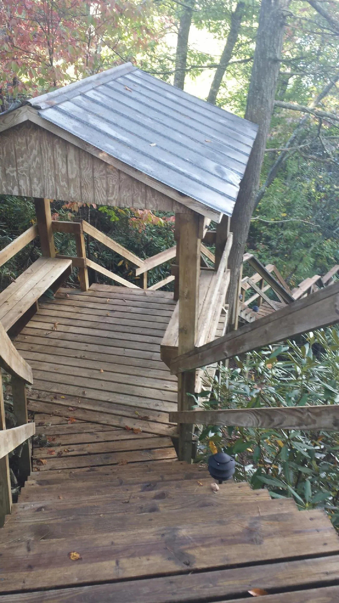 Metal roofed shelter over wooden steps on a wooded walkway — Skylight Repair & Installation work by our crew in Calimesa